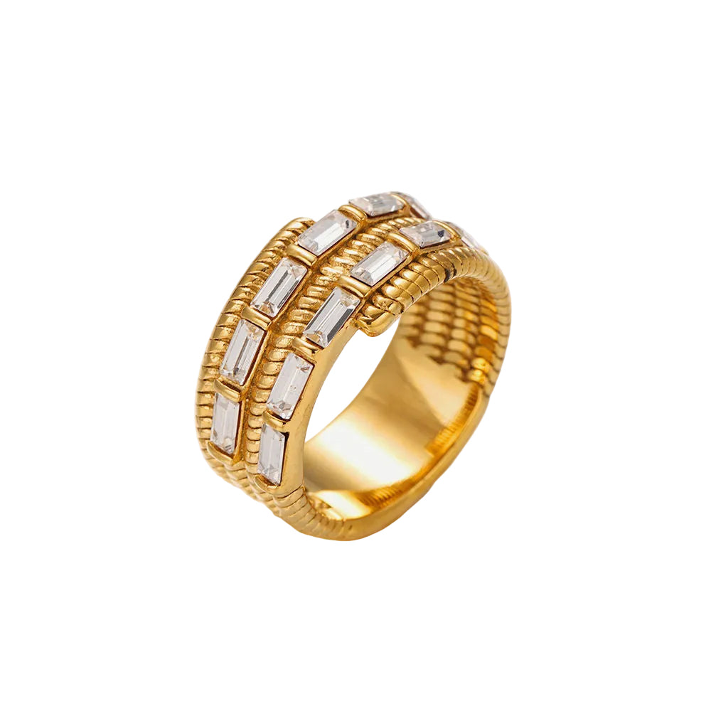 A gold ring featuring three parallel rows of baguette-cut clear stones, set in a textured basketweave-style band, photographed on a clean white background.